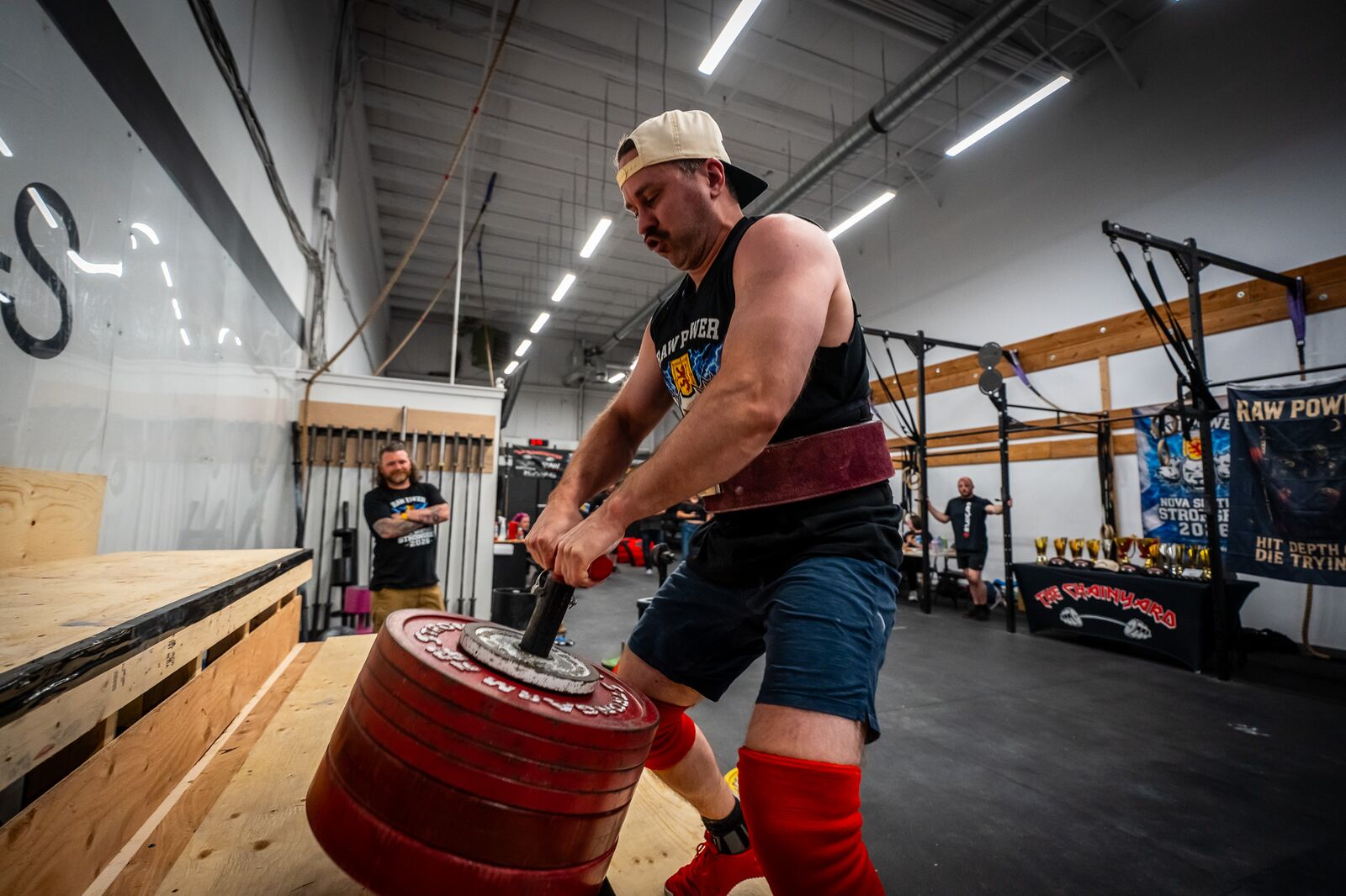 New Scotland Strength client lifting a stack of plates by the handle